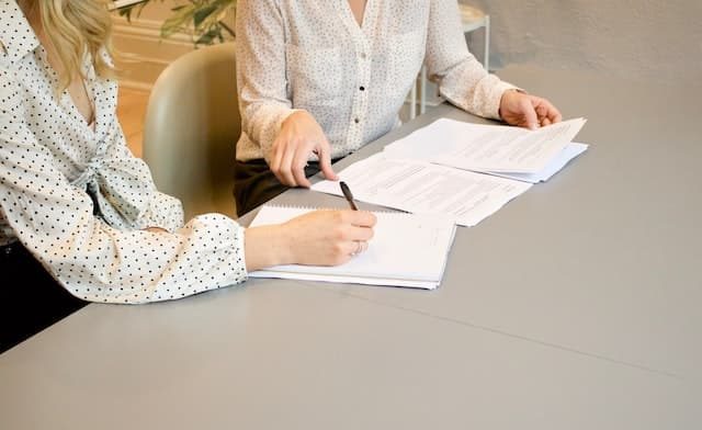 2 personnes signant un contrat