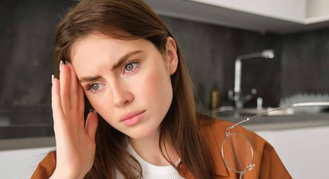 femme se touchant la tête et ayant mal à la tête