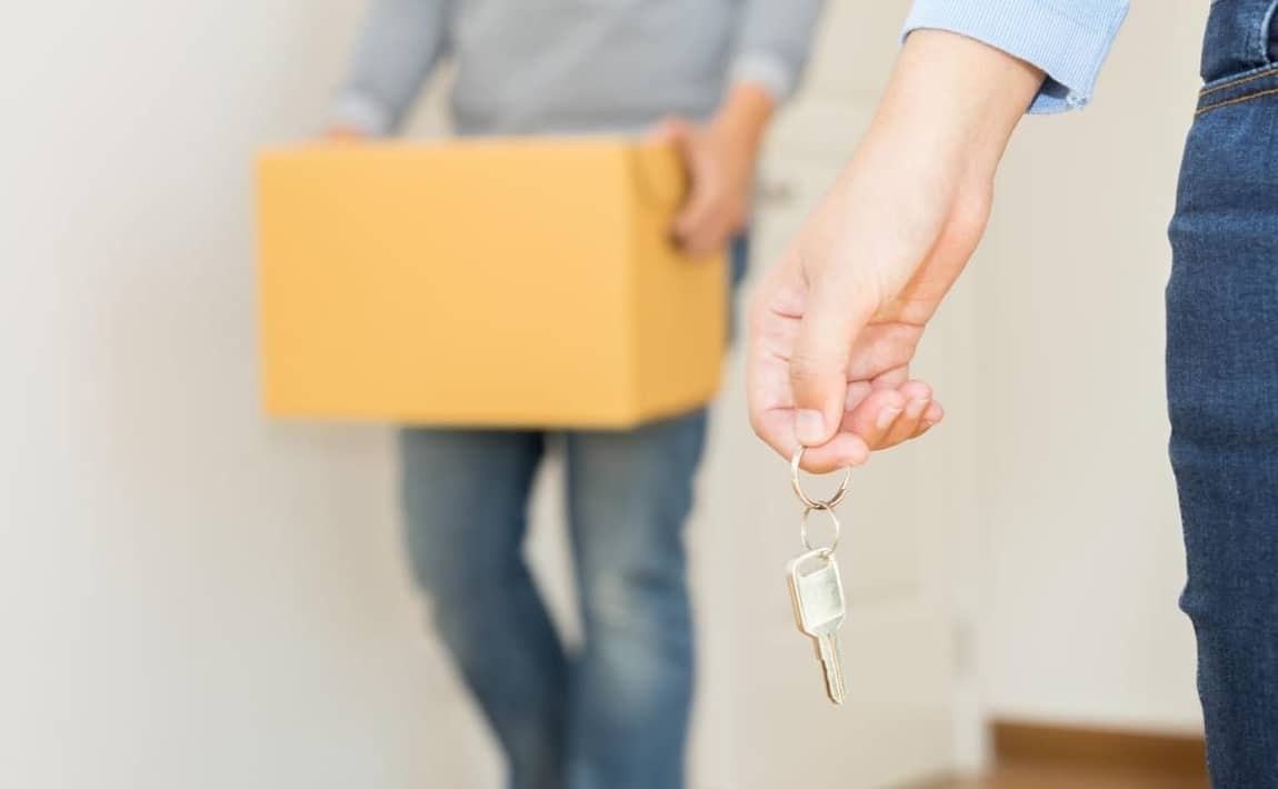 Homme tenant un carton et une femme tenant une clé